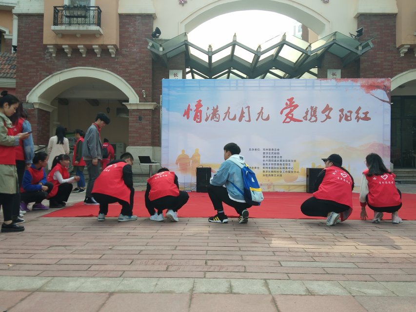 志愿者帮助社区工作人员布置活动场地